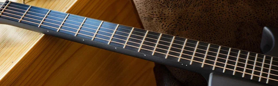Close-up of the guitar’s molded carbon-fiber bridge and saddle design for durable string anchoring.
