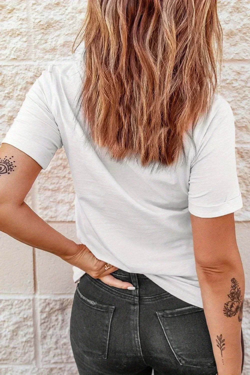 Back of the women’s music note tee showing its plain white back and relaxed fit.