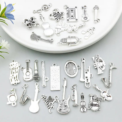 A silver guitar charm used on a handmade necklace, showing a real-world application.